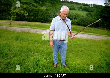 A water dowser looking for water on farm land in Devon uk. Stock Photo
