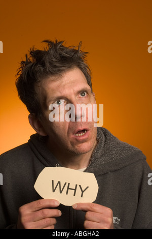 Scary looking man holding a sign reading "Why Stock Photo