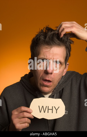 Scary looking man holding a sign reading "Why Stock Photo