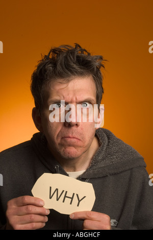 Scary looking man holding a sign reading "Why Stock Photo