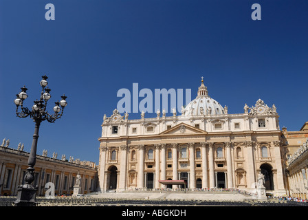 Front of Saint Peters Papal Basilica Vatican in Rome Italy in sunshine with lamp and blue sky Stock Photo