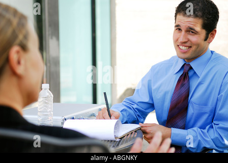 Businessman  in tie interviewing a female candidate for job Stock Photo
