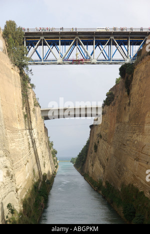 Steep limestone walls of narrow Greek Corinth Canal spectators on road bridge watch cruise ship below Isthmia Peloponnese Greece Europe Stock Photo