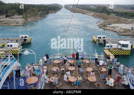 Passengers on stern leisure deck of Cruise ship passing over submersible road bridge across Corinth Canal connects Gulf of Corinth with Saronic Gulf Stock Photo