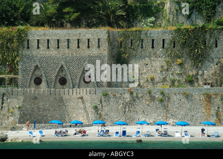 Private beach in front of historical fortifications part UNESCO Amalfi coast elevators link to hotel buildings high above, Amalfi town Campania Italy Stock Photo