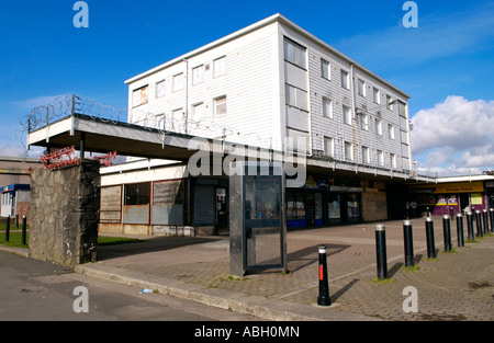 Derelict block of flats boarded up on run down shopping centre with razor wire on Gurnos Estate Merthyr Tydfil South Wales UK Stock Photo