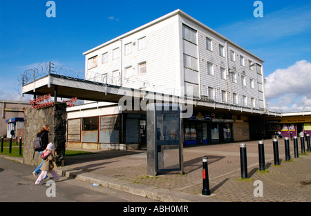 Derelict block of flats boarded up on run down shopping centre with razor wire on Gurnos Estate Merthyr Tydfil South Wales UK Stock Photo