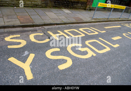 Bilingual Welsh English language parking sign on road outside primary school Cardiff South Wales UK Stock Photo