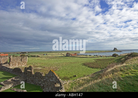 Lindisfarne Priory National Trust in foreground and Lindisfarne Castle in distance Holy Island Northumberland UK Stock Photo