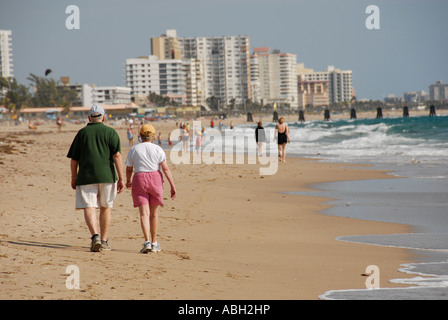 Older couple walking on beach Stock Photo