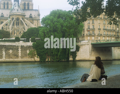 Couple at Ile St Louis on River Seine across from Notre Dame in Paris Stock Photo