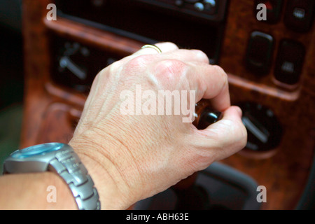 Male drivers hand on automatic gear shift lever Stock Photo