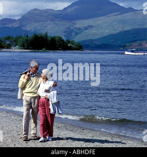 COUPLE WALKING ON BEACH LOCH LOMOND.MODEL RELEASE AVAILABLE ON REQUEST . Stock Photo
