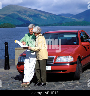 MATURE COUPLE WITH CAR READING MAP LOCH LOMOND SCOTLAND Stock Photo