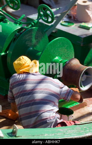 FISHERMAN PAINTING TRAWLER FISHING BOAT'S WINCH WITH GREEN PAINT  ERQUY  HARBOUR BRITTANY FRANCE Stock Photo