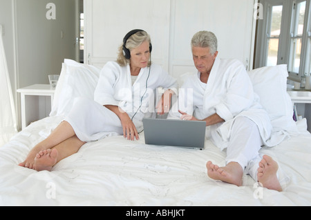 Couple using laptop in bed Stock Photo