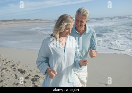 Smiling couple running on the beach Stock Photo