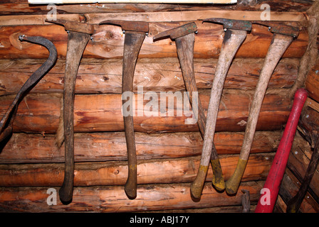 Display of lumberjack tools hanging on a wall inside a forge Stock Photo