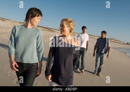 2 couples walking on the beach Stock Photo