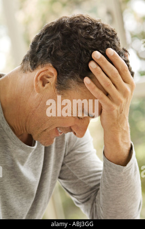 Portrait of man with hand on forehead Stock Photo
