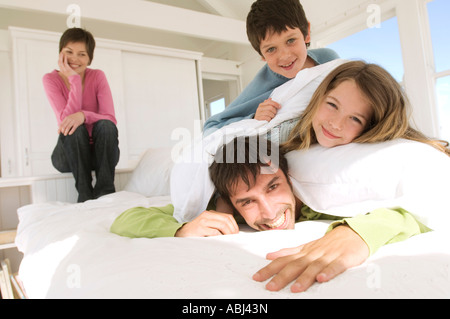 Smiling couple and two children on bed