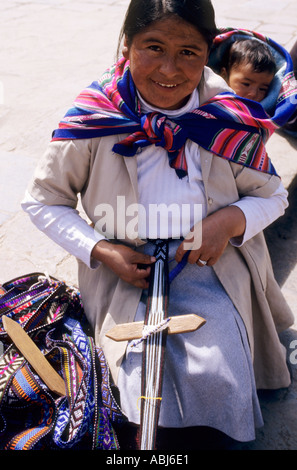 Cusco, Peru. Woman using a foot loom to weave traditional strap belts. Stock Photo