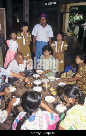 Buddhist family having lunch in a temple precincts in Burma on the occasion of wesak, the Buddha`s birthday Stock Photo