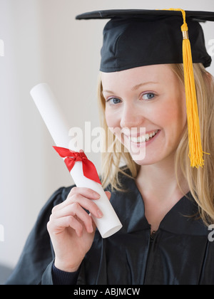 Woman wearing graduation cap and gown Stock Photo