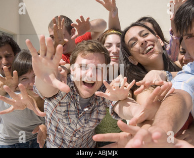 Friends reaching out hands and laughing Stock Photo