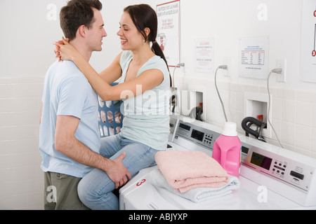 Couple hugging in laundry room Stock Photo