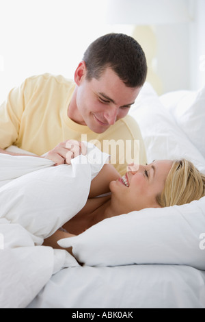 Couple smiling at each other in bed Stock Photo
