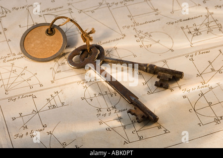 Old fashioned keys on sheet of geometry Stock Photo