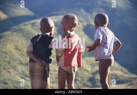 Three Afrian children stand in the mountainous scenery of Lesotho, Southern Africa Stock Photo