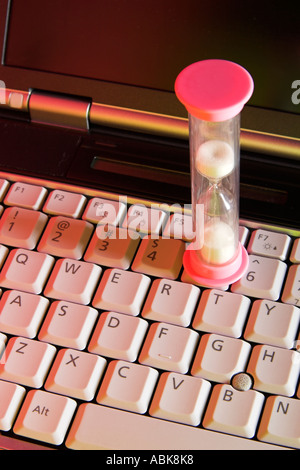An hourglass on a computer keyboard Stock Photo