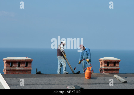 Men working on roof in sunny Dubrovnic, Croatia Stock Photo