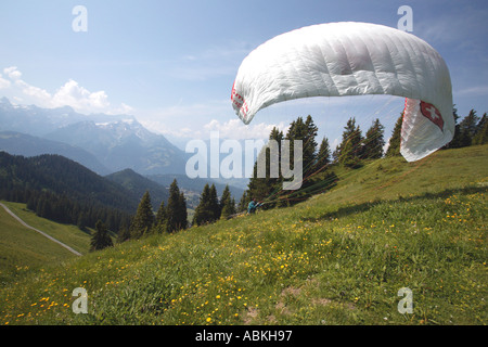Paraglider preparing his shute for take off for a flight over Villars in Valais region of Switzerland Europe Stock Photo