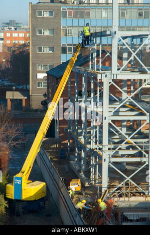 Welder working from a mobile access platform on a construction site in Manchester, England, UK Stock Photo