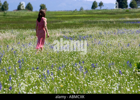 Woman walking through a meadow of wildflowers including the camas lily in Valley County Idaho MR Stock Photo