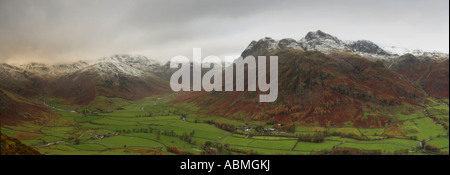 horizontal panoramic landscape autumn colours in the great langdale valley in the english lake district with snow capped langdal Stock Photo