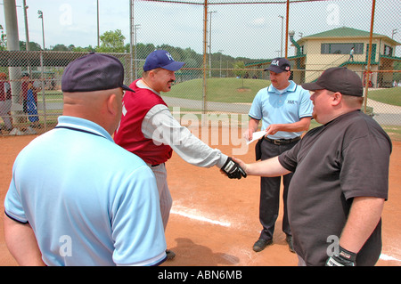 New softball umpires for ASA organization in USA and America during games and in pregame checking bats and lineups and rules and such for team games Stock Photo