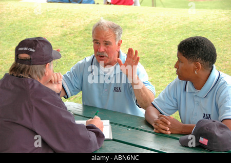 New softball umpires for ASA organization in USA and America during games and in pregame checking bats and lineups and rules and such for team games Stock Photo