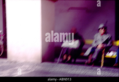 Blurred Italians on a bench Stock Photo