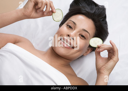 Woman removing cucumbers from eyes Stock Photo