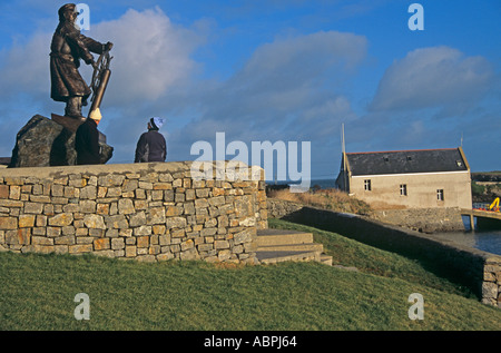 MOELFRE ISLE OF ANGLESEY NORTH WALES UK December Bronze statue of Dic Evans MBE a RNLI coxswain the lifeboat station behind Stock Photo