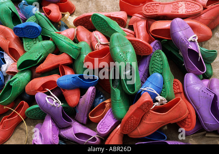 Lolgorian, Kenya. Brightly coloured plastic shoes on sale at the market
