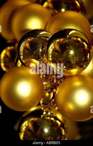 Gold baubles Christmas decorations hanging from ceiling display Stock Photo