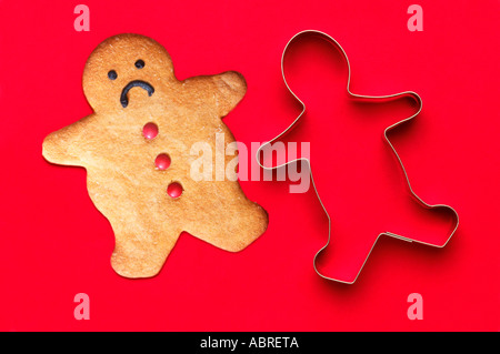 Ginger Statistics, Not Fitting The Mold. Gingerbread Man next To Cutter Stock Photo