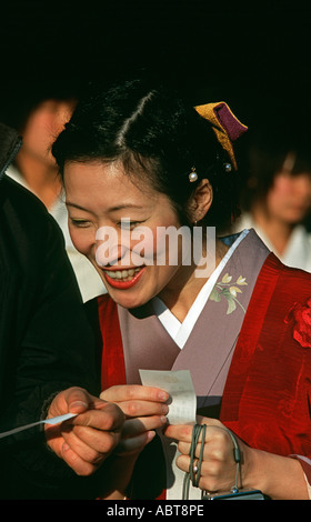 Japanese woman in a kimono reading her New Year fortune New Years Day Kashihara shrine Nara prefecture Japan Stock Photo