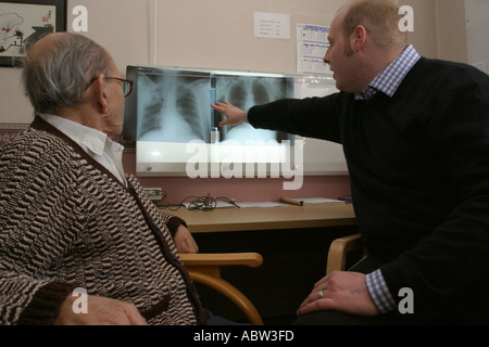 A patient and male nurse examine x rays,  Tuberculosis clinic, Whipps Cross Hospital, London, UK. Stock Photo