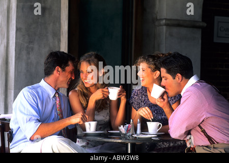 Two young couples age 30s having coffee together in café laughing Stock Photo
